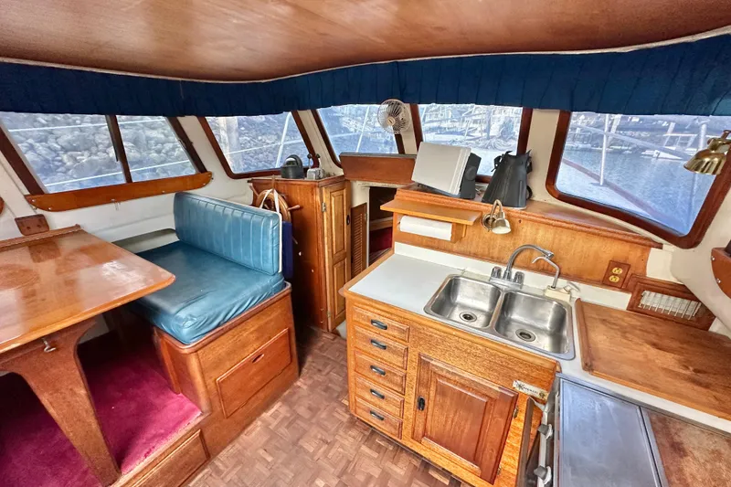 Slide: The Image of Interior of a 1970 CAL 46 Cruiser featuring a cozy dining area and compact kitchen. - 9