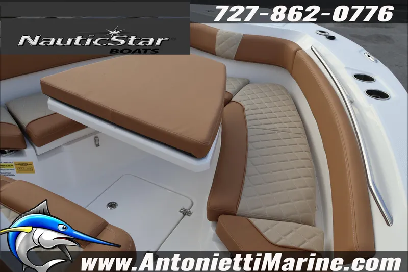 Slide: The Image of 2026 NauticStar 222 Offshore boat interior with tan seating, contact info, and logo. - 16