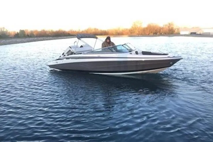 Slide: The Image of 2026 Crownline 288 SS boat cruising on a calm lake at sunset. - 15