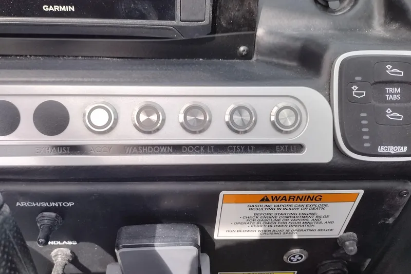 Slide: The Image of Control panel of a 2026 Crownline 288 SS boat with various switches and warning label. - 30