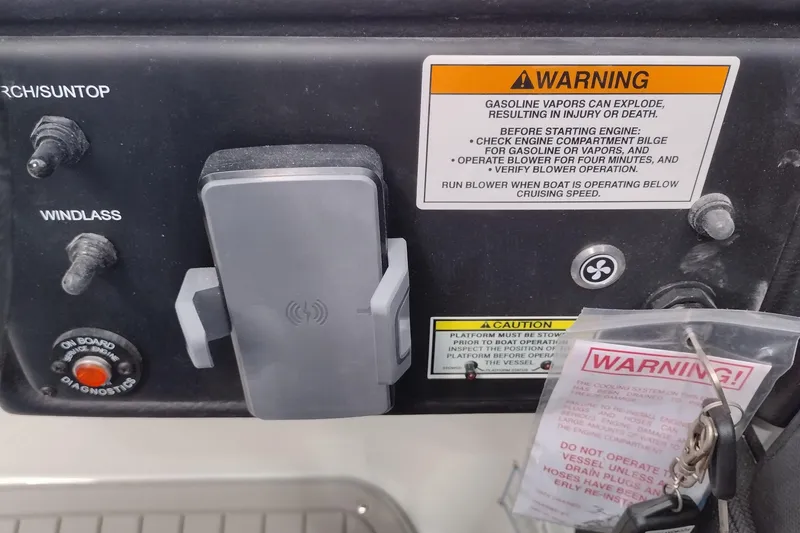 Slide: The Image of Control panel of a 2026 Crownline 288 SS boat with warning labels and switches. - 33