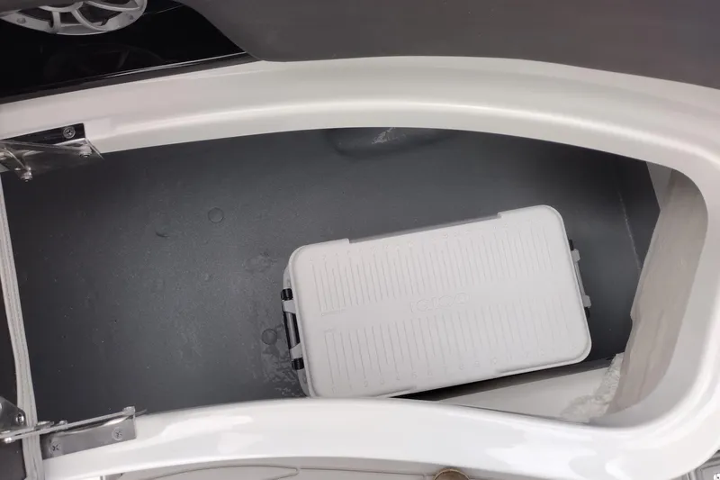 Slide: The Image of 2026 Crownline 288 SS boat storage compartment with a white cooler inside. - 52
