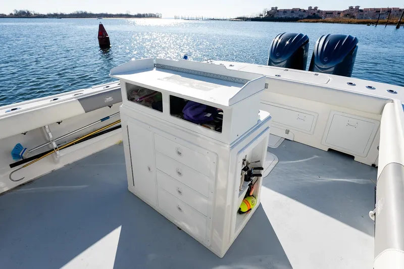 Slide: The Image of 2024 Steiger Craft 31 Fisherman boat deck with storage and twin engines on a sunny day. - 16