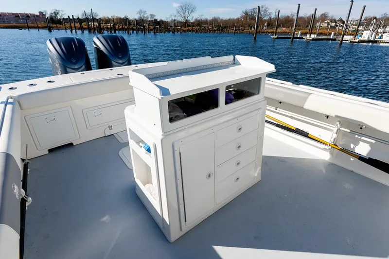 Slide: The Image of 2024 Steiger Craft 31 Fisherman boat interior with storage and dual engines on a calm water backdrop. - 17