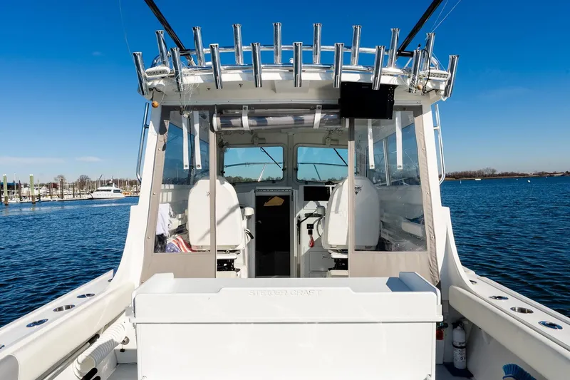 Slide: The Image of 2024 Steiger Craft 31 Fisherman boat, rear view, docked on calm water under clear blue sky. - 25