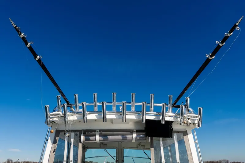 Slide: The Image of 2024 Steiger Craft 31 Fisherman boat with fishing rod holders against clear blue sky. - 26