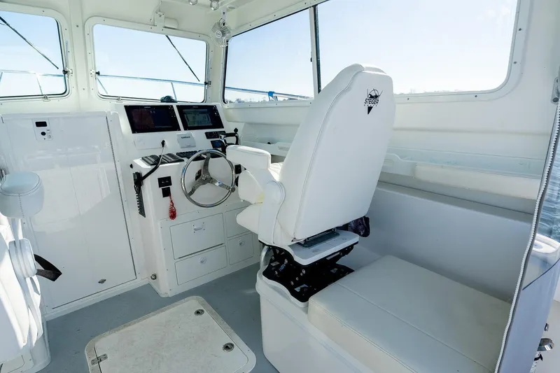 Slide: The Image of 2024 Steiger Craft 31 Fisherman boat interior with helm, steering wheel, and navigation equipment. - 29