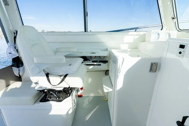 Slide: The Image of 2024 Steiger Craft 31 Fisherman interior with white captain's chair and control panel. - 34