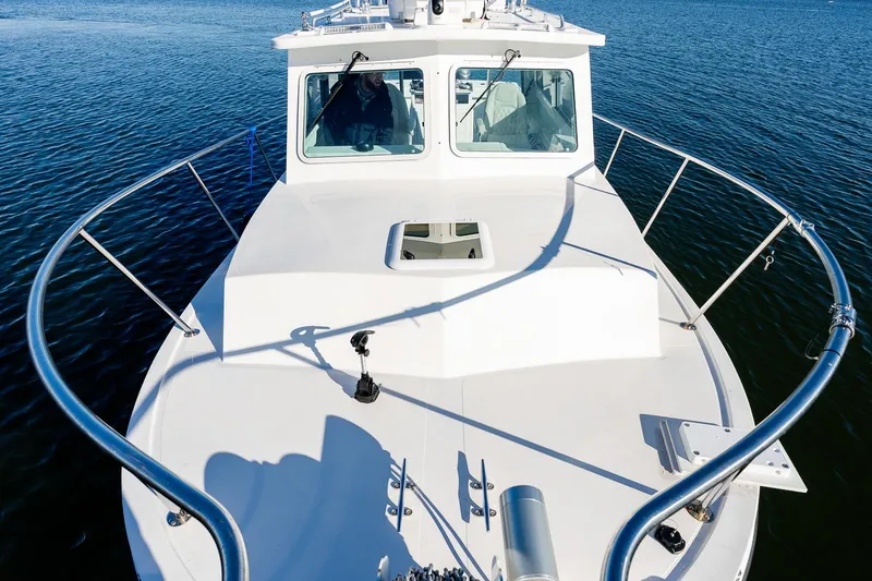 Slide: The Image of 2024 Steiger Craft 31 Fisherman boat on calm water, showcasing bow and cabin. - 38