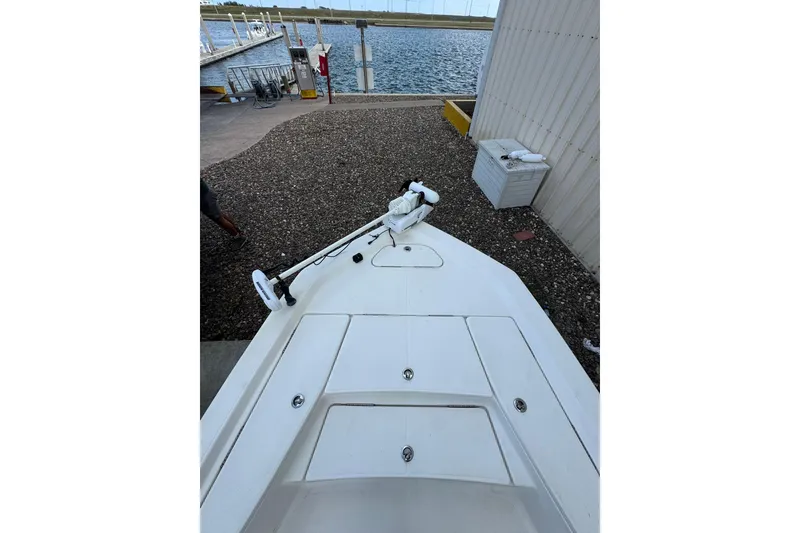 Slide: The Image of 2017 Blue Wave 2200 STL boat docked near a waterfront, showcasing its bow and deck. - 8