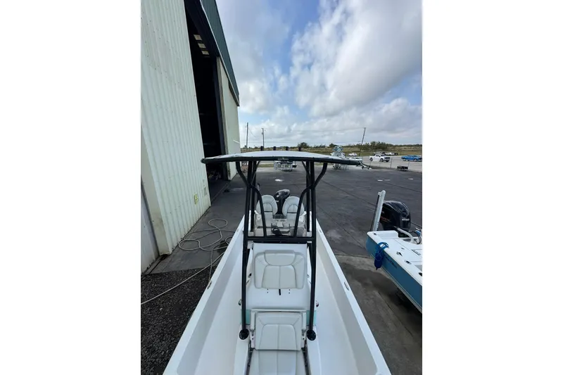 Slide: The Image of 2017 Blue Wave 2200 STL boat docked near a large warehouse under a cloudy sky. - 9