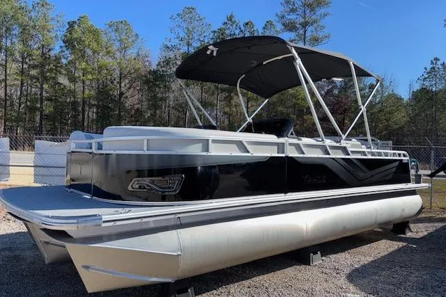 Slide: The Image of 2026 Tahoe Pontoon SP 2385 EL with canopy, parked outdoors, surrounded by trees. - 4