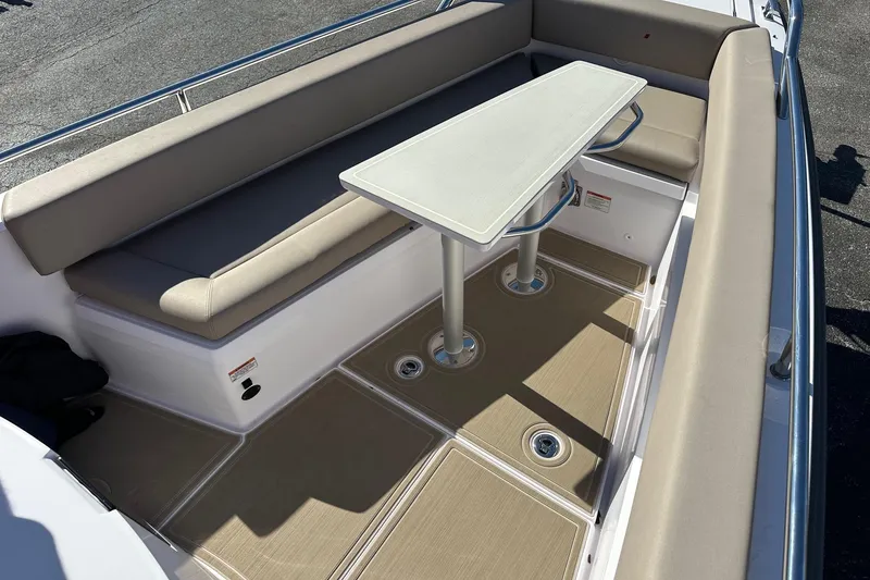 Slide: The Image of 2022 Axopar 28 CABIN boat interior with beige seating and table. - 10