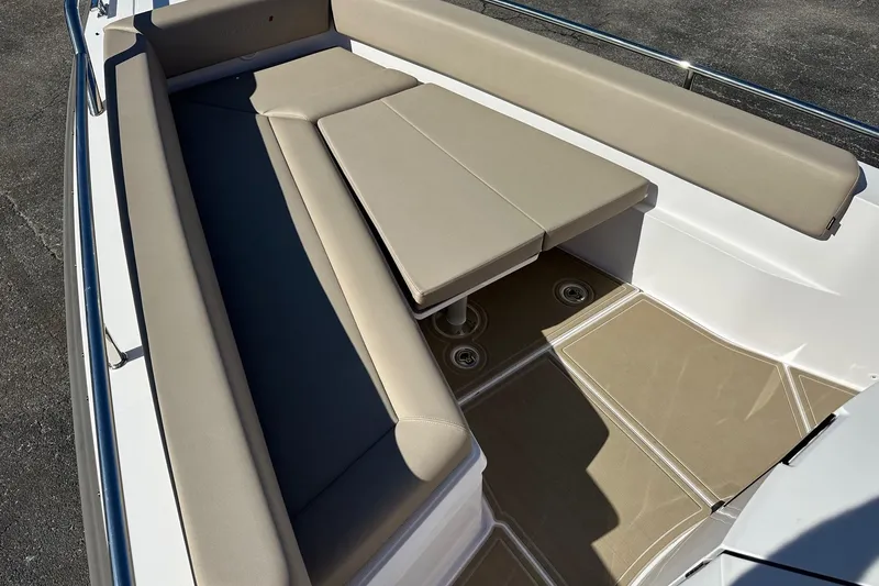 Slide: The Image of 2022 Axopar 28 CABIN boat interior with beige seating and table. - 13