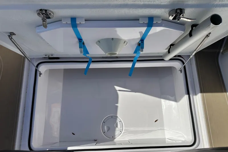 Slide: The Image of Storage compartment of 2022 Axopar 28 CABIN boat, featuring secure latches and blue straps. - 15