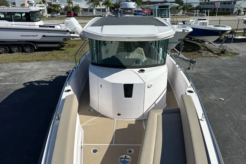 Slide: The Image of 2022 Axopar 28 CABIN boat with sleek design, docked outdoors. - 16