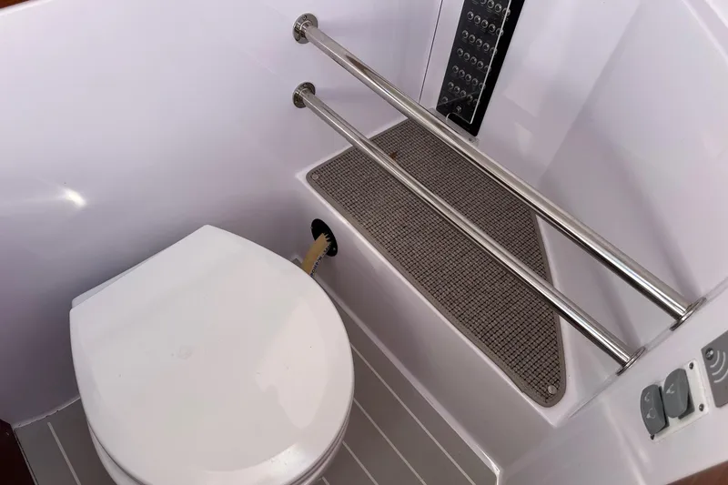 Slide: The Image of Interior of 2022 Axopar 28 CABIN boat bathroom with toilet and shower area. - 18