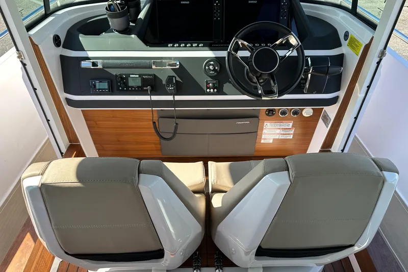 Slide: The Image of 2022 Axopar 28 CABIN boat interior with modern dashboard and dual seats. - 22