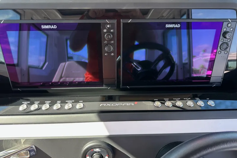Slide: The Image of Dashboard of 2022 Axopar 28 CABIN with dual Simrad displays and control buttons. - 24