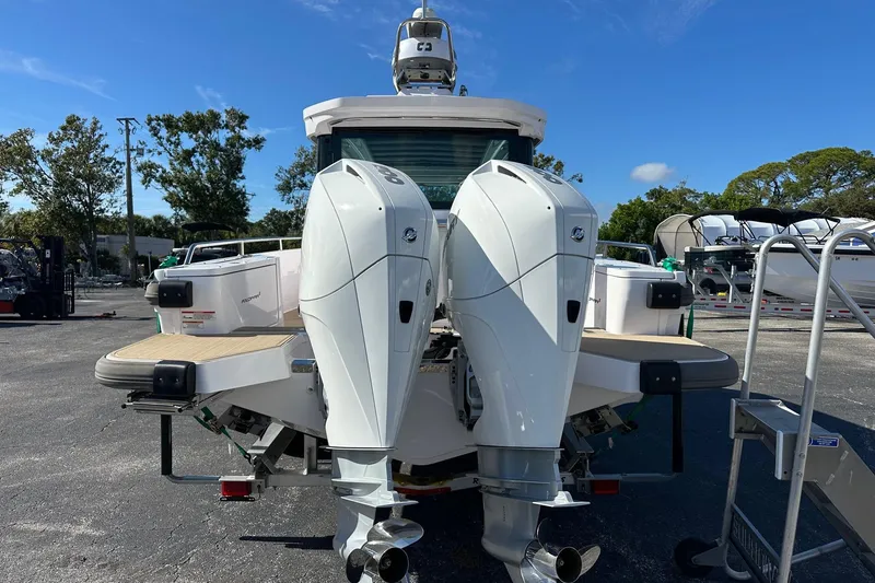 Slide: The Image of 2022 Axopar 28 CABIN boat with dual outboard motors, parked outdoors. - 3