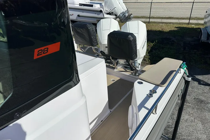 Slide: The Image of 2022 Axopar 28 CABIN boat with dual outboard motors, docked on a sunny day. - 33