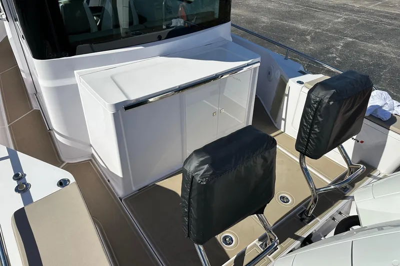 Slide: The Image of 2022 Axopar 28 CABIN boat interior with covered seats and storage area. - 34