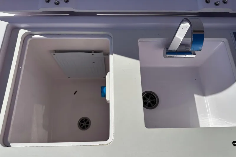 Slide: The Image of Axopar 28 CABIN 2022 boat sink and storage compartment with modern faucet. - 38