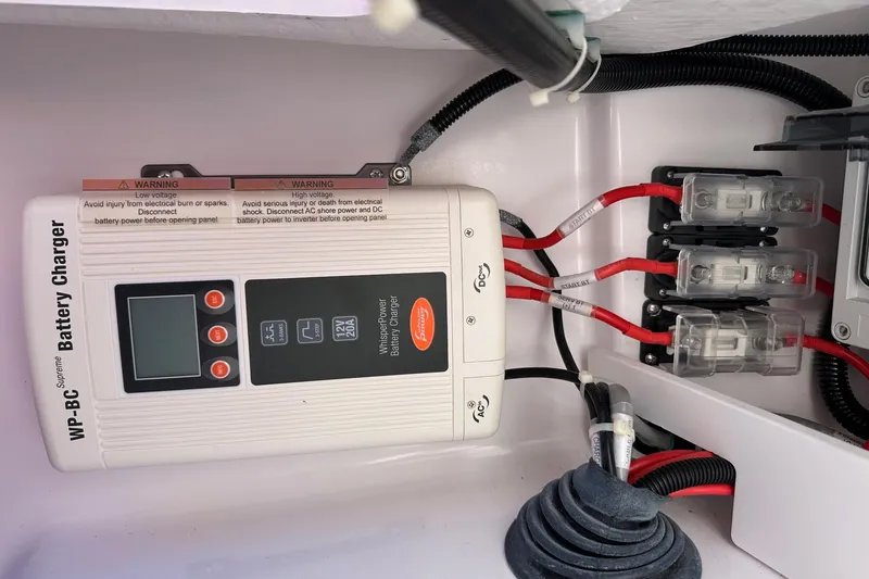 Slide: The Image of Battery charger setup in 2022 Axopar 28 CABIN boat, featuring wiring and safety warnings. - 40