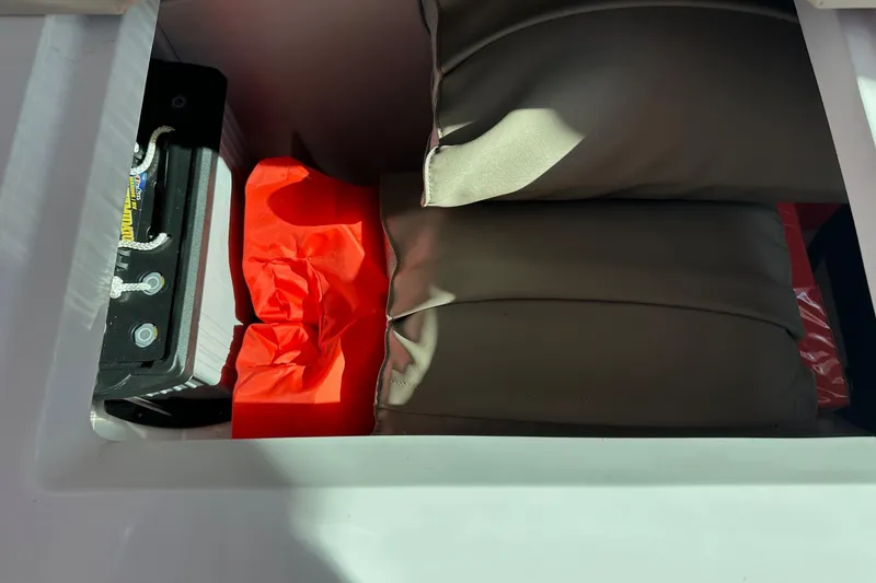 Slide: The Image of Storage compartment in 2022 Axopar 28 CABIN with life jackets and battery. - 48