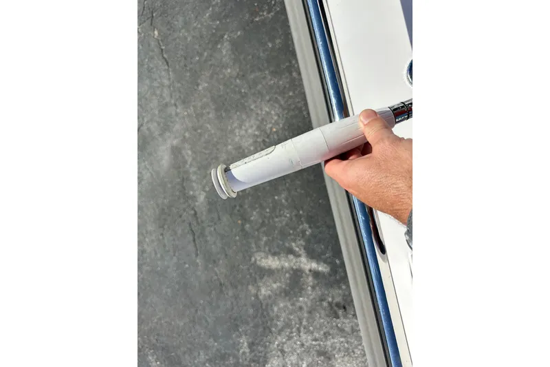 Slide: The Image of Hand holding a white handle near a 2022 Axopar 28 CABIN boat on pavement. - 50