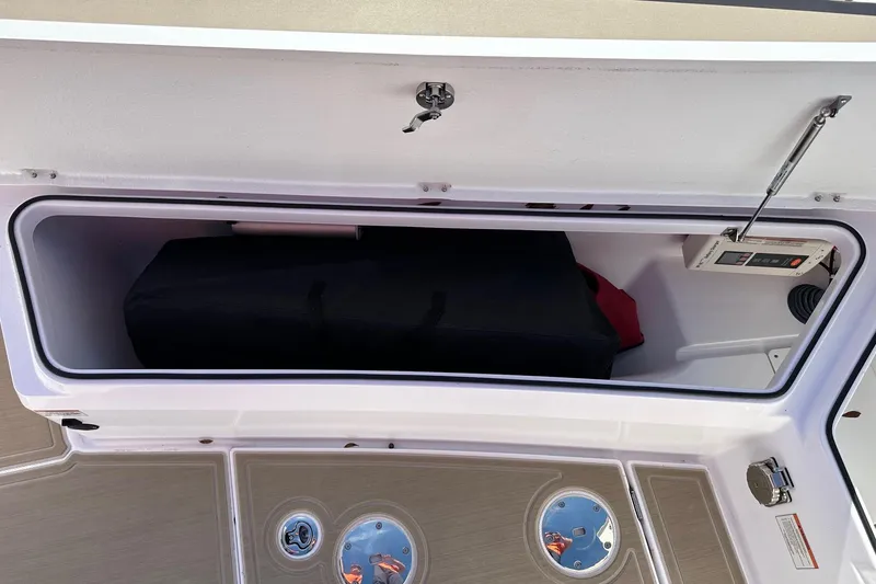 Slide: The Image of Storage compartment in 2022 Axopar 28 CABIN boat, featuring secure latch and organized interior. - 51