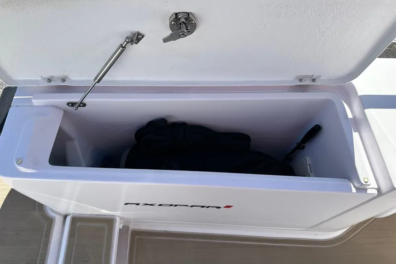 Slide: The Image of Open storage compartment on 2022 Axopar 28 CABIN boat, showing interior space. - 52