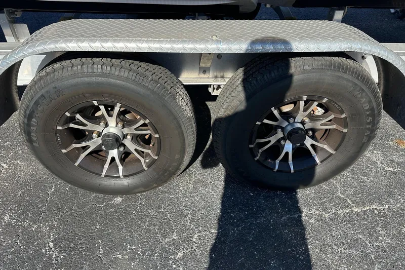 Slide: The Image of Trailer wheels for 2022 Axopar 28 CABIN boat on asphalt surface. - 54