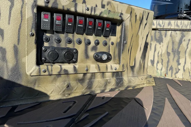 Slide: The Image of Control panel of 2026 SeaArk 1960 Slayer Pro boat with camouflage design. - 14