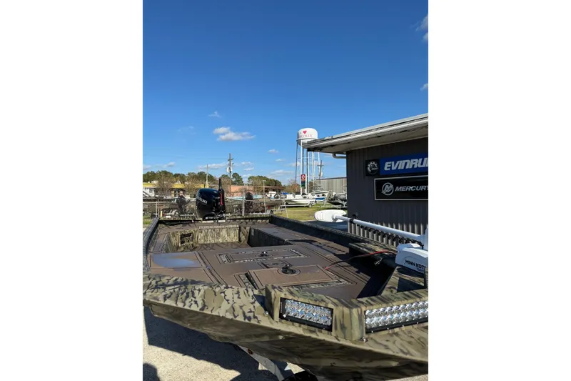 Slide: The Image of 2026 SeaArk 1960 Slayer Pro boat with camouflage design, parked outdoors under clear blue sky. - 3