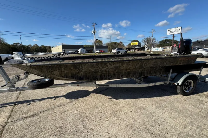 Slide: The Image of 2026 SeaArk 1960 Slayer Pro boat on trailer, parked outdoors under clear blue sky. - 4