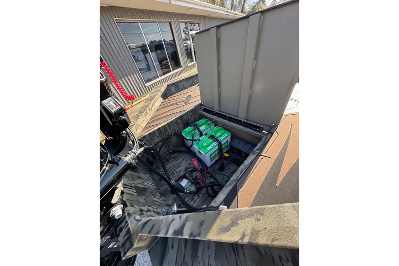 Slide: The Image of 2026 SeaArk 1960 Slayer Pro boat with open storage compartment and visible batteries. - 8