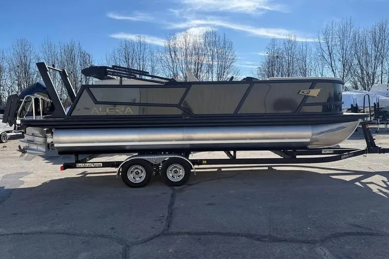 Slide: The Image of 2026 Alera MQ23 pontoon boat on trailer, parked outdoors under clear sky. - 4