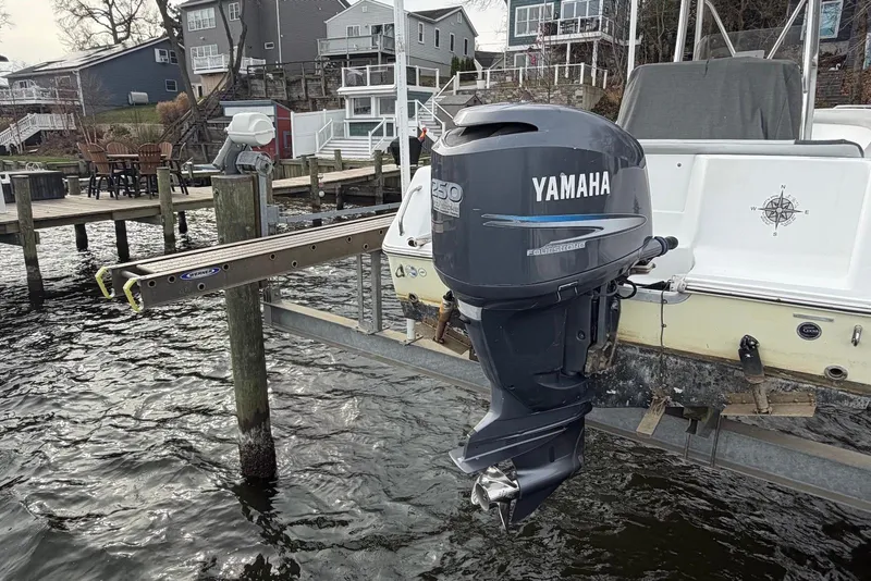 Slide: The Image of 2009 Sea Hunt Ultra 232 with Yamaha outboard motor on a boat lift by a dock. - 11