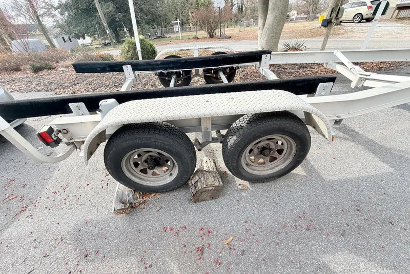 Slide: The Image of Trailer for 2009 Sea Hunt Ultra 232 boat, parked on pavement with wooden block. - 13