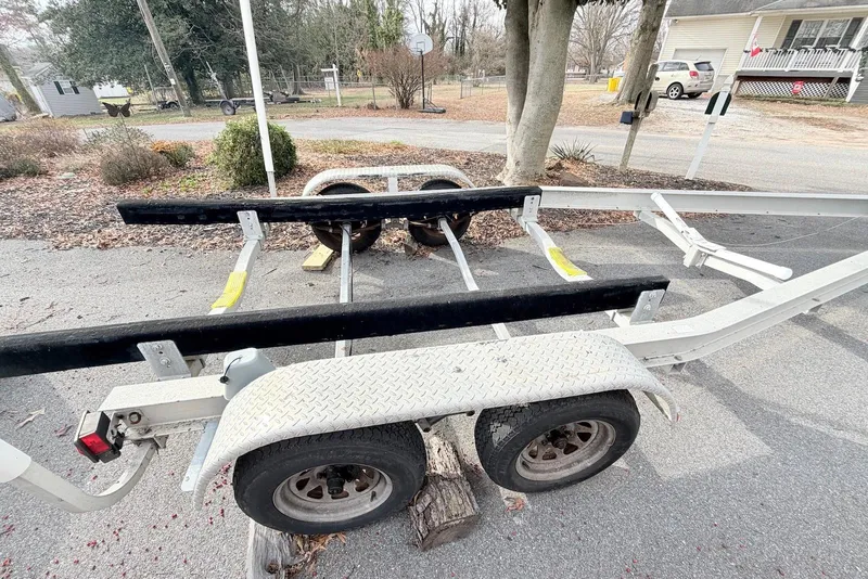 Slide: The Image of Boat trailer for 2009 Sea Hunt Ultra 232, parked on a residential driveway. - 14