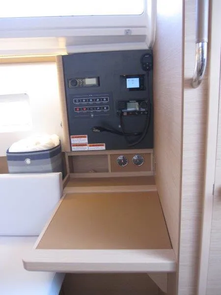 Slide: The Image of Navigation station of 2024 Jeanneau 380 sailboat with control panel and storage. - 13