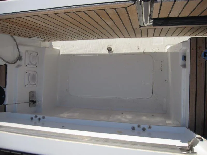 Slide: The Image of 2024 Jeanneau 380 boat interior with wooden deck and storage compartment. - 42