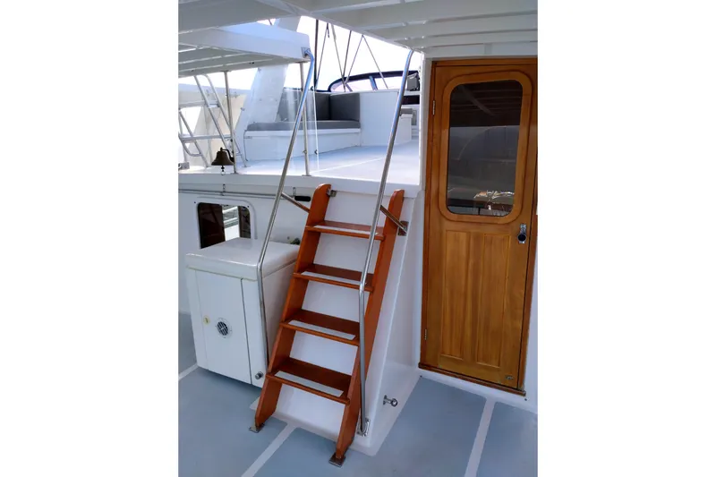Slide: The Image of 1994 DeFever Double Cabin yacht with wooden stairs and door, showcasing elegant design. - 11