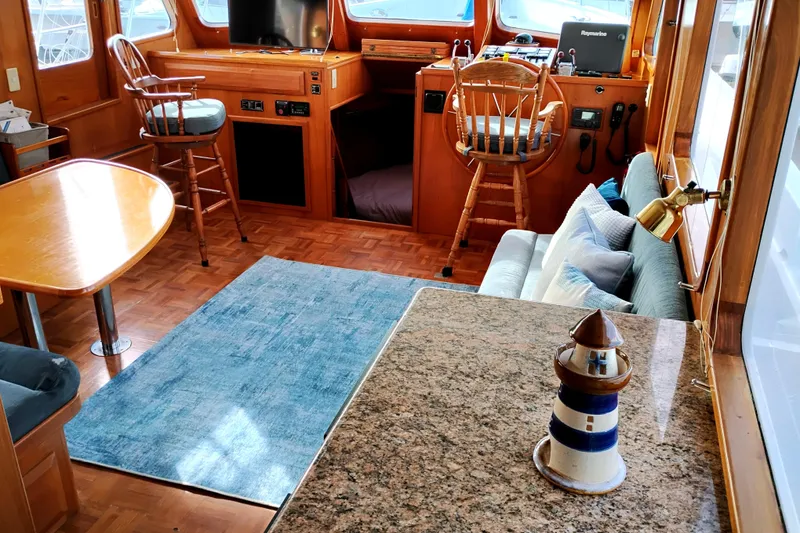 Slide: The Image of 1994 DeFever Double Cabin interior with wood accents, blue rug, and nautical decor. - 12