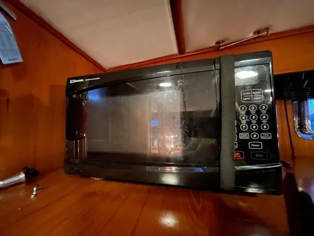 Slide: The Image of Microwave in 1994 DeFever Double Cabin, wooden interior, secured with strap. - 17