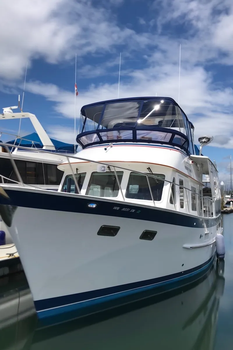 Slide: The Image of 1994 DeFever Double Cabin yacht docked under a partly cloudy sky. - 2