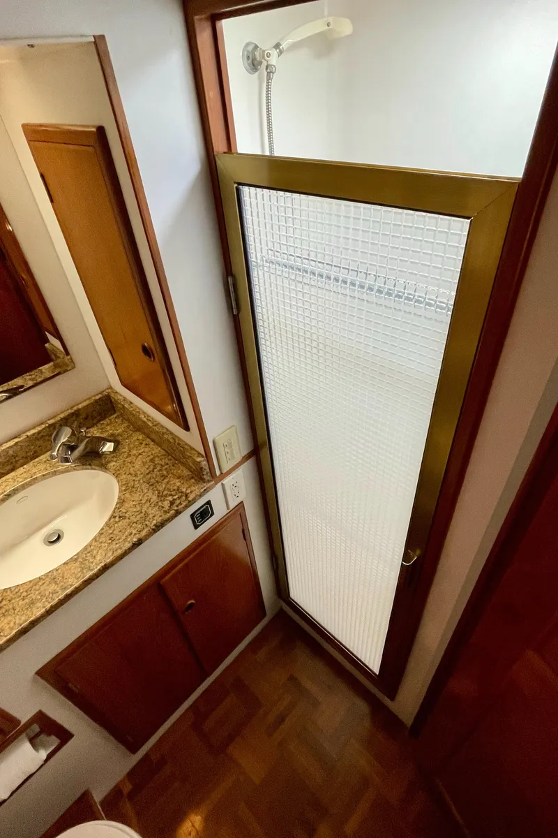 Slide: The Image of 1994 DeFever Double Cabin bathroom with shower, sink, and wooden cabinetry. - 24