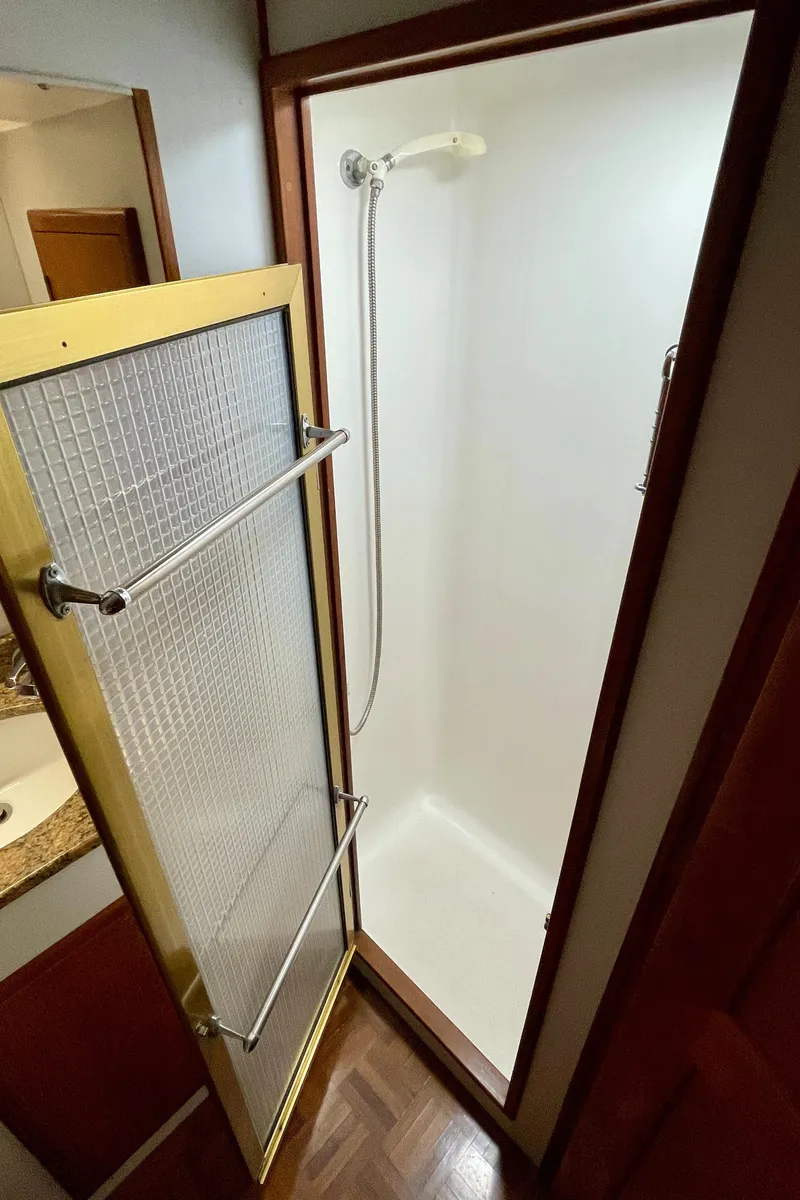 Slide: The Image of Shower area in 1994 DeFever Double Cabin yacht, featuring a glass door and handheld showerhead. - 25