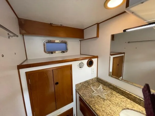 Slide: The Image of 1994 DeFever Double Cabin bathroom with wooden cabinets, granite countertop, and small window. - 28